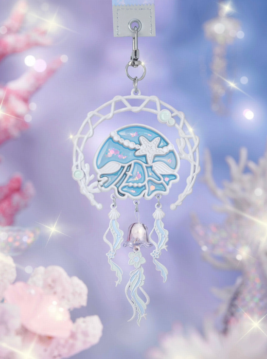 Crafted with semi-transparent glass enamel and embossed detailing,
the design outlines the “Ocean Dream” dreamcatcher motif.

Shimmering flecks of light dance across the surface of the jellyfish,
as if refracted by the ocean into scattered stardust.
In that instant,
the moment is captured and made eternal.