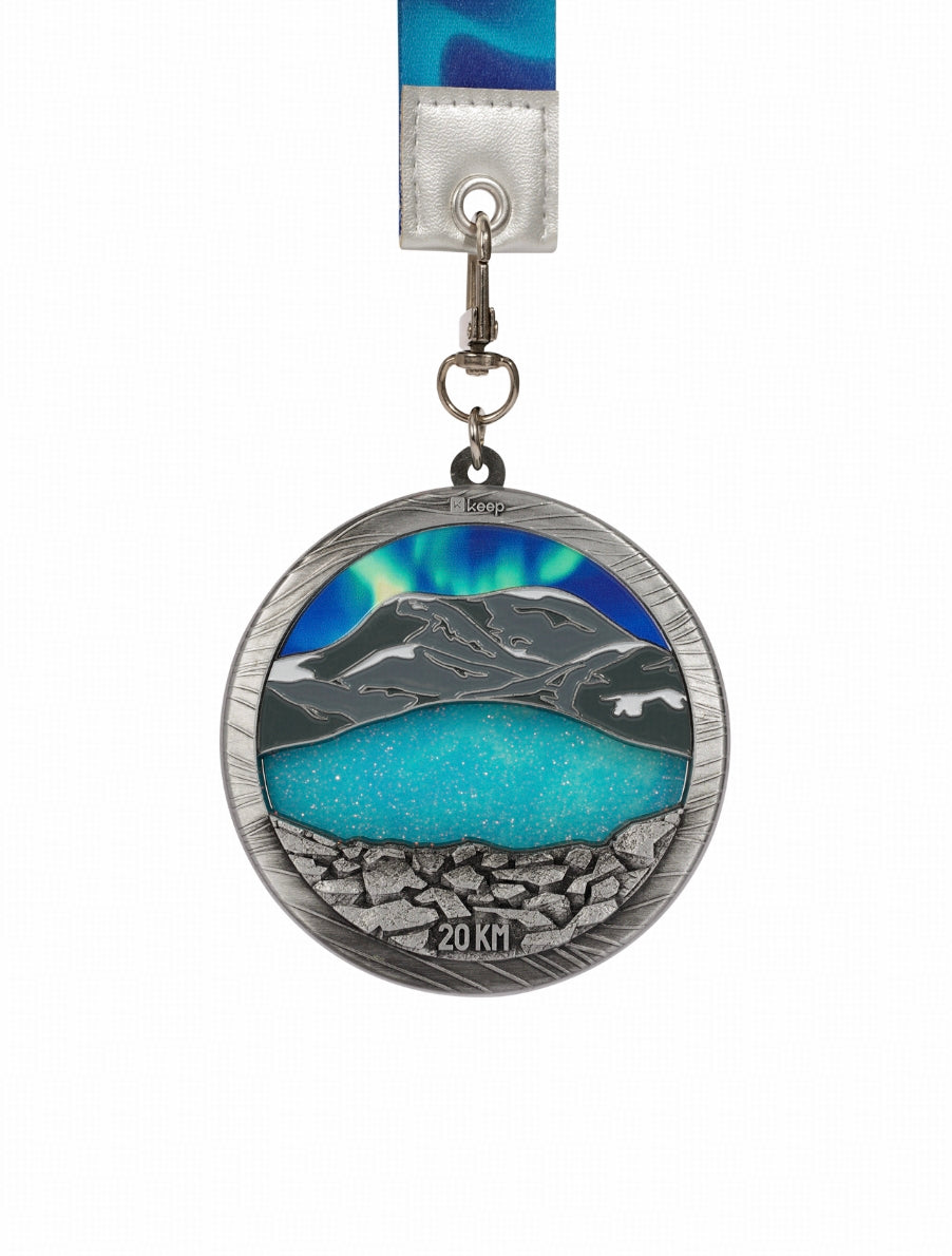 Third Stop — Lake of Shimmering Light

Ride a highland mountain bike onto the road,
passing through landscapes embraced by rolling mountains,
heading toward sapphire-blue waters and a sky filled with stars,
moving forward with longing and devotion.

The front of the medal recreates the spirit of alpine lakes,
as cold and majestic as Heavenly Lake,
and as bright and ethereal as Sayram Lake—
all condensed within a small, defined space.