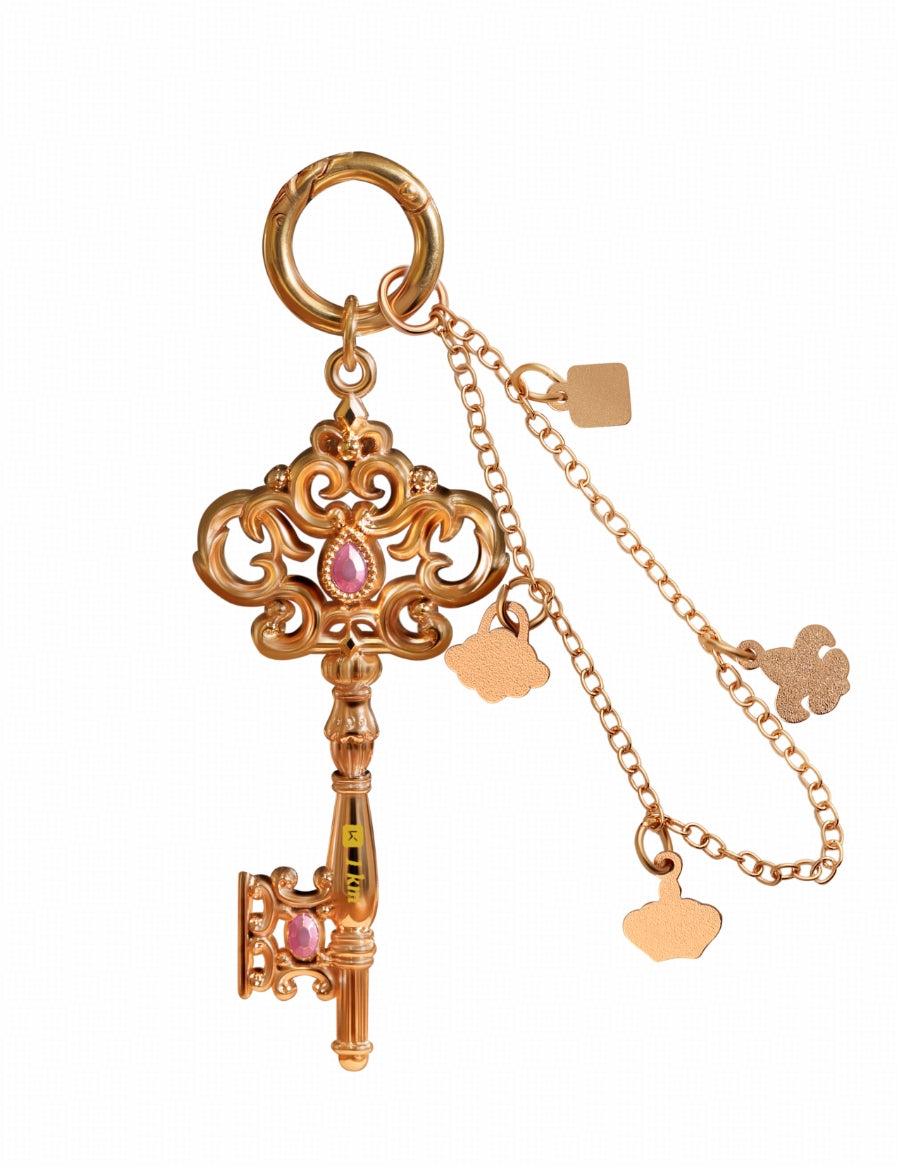The design features an elegant key-shaped silhouette in a soft pink-gold tone as the main palette.
European court-inspired hollow-carving techniques are paired with a gemstone-like translucent glaze,
creating a piece that is both delicate in form and rich in the idea of “gentle strength.”

The lightweight chain is adorned with miniature charms—crowns, locks, ornamental motifs, and more—
forming a “miniature treasure collection on the wrist.”

With every movement, soft, delicate sounds accompany you like gen