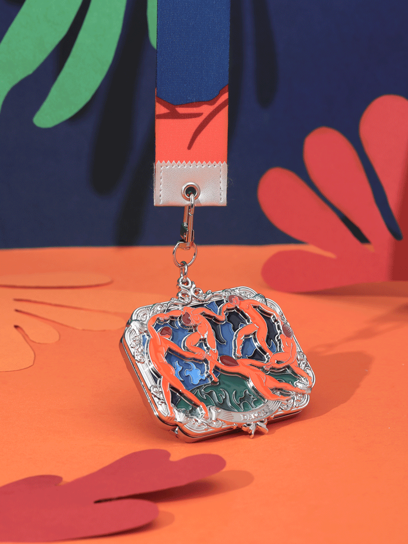The front employs miniature embossing to faithfully reproduce the core composition of The Dance.
The figures form a circle, with fluid movements full of rhythm and energy.
It highlights Matisse’s signature vibrant colors and striking contrasts,
allowing the medal to convey the original painting’s sense of life and joyous atmosphere even in the smallest details.
